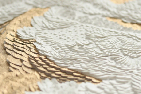 Accueil Bas-relief papier incisé bicolore, blanc immaculé rehaussé de feuilles d'or. Sculpture abstraite sur papier, jouant sur le contraste entre la simplicité du volume et la préciosité de l'ornementation. Papiers sculptés réalisé par l'artiste artisane d'art Vanessa Campos