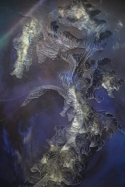 Portfolio Bas-relief papier de la série "Échos des Abysses", dominé par le bleu outremer profond et des écailles incisées. L'œuvre présente une forme ondulatoire de serpent marin, traversée par un trait de lumière vertical en pigment or, symbolisant l'éclaircie dans l'obscurité des abysses.